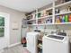 Laundry room with washer, dryer, and ample storage shelving at 3124 Lecanto St, Holiday, FL 34691