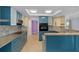 Updated kitchen with teal cabinets, granite countertops, and stainless steel appliances at 3849 Staysail Ln, Holiday, FL 34691