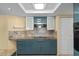 Modern kitchen with teal cabinets, granite countertops, and stainless steel appliances at 3849 Staysail Ln, Holiday, FL 34691