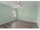 Light green bedroom with wood-look floors and ceiling fan at 3849 Staysail Ln, Holiday, FL 34691