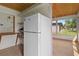 Laundry room with white refrigerator and access to a screened porch at 3849 Staysail Ln, Holiday, FL 34691