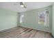 Bright bedroom featuring light green walls and wood-look floors at 3849 Staysail Ln, Holiday, FL 34691