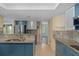 Modern kitchen with teal cabinets, granite counters, and tile backsplash at 3849 Staysail Ln, Holiday, FL 34691