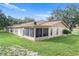 Rear view of house showing screened patio and yard at 3849 Staysail Ln, Holiday, FL 34691