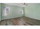 Light green bedroom with wood-look floors and ceiling fan at 3849 Staysail Ln, Holiday, FL 34691