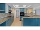 Updated kitchen with teal cabinets, granite countertops, and stainless steel appliances at 3849 Staysail Ln, Holiday, FL 34691