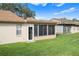 Back exterior showing multiple screened porches and grassy yard at 3849 Staysail Ln, Holiday, FL 34691