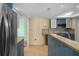 Modern kitchen with teal cabinets, granite counters, and tile backsplash at 3849 Staysail Ln, Holiday, FL 34691