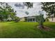 Landscaped backyard with view of the home's exterior at 9727 Oakwood Hills Ct, New Port Richey, FL 34655