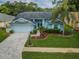 Single-Gathering home with light blue exterior and palm trees at 9727 Oakwood Hills Ct, New Port Richey, FL 34655
