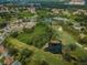 Aerial view of community, showcasing homes, golf course, and pond at 9727 Oakwood Hills Ct, New Port Richey, FL 34655