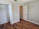 Bedroom with wood floors, bi-fold door closet, and a doorway to adjacent room at 5265 E Bay Dr # 420, Clearwater, FL 33764