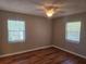 Bright bedroom featuring hardwood floors, ceiling fan, and two windows for natural light at 5265 E Bay Dr # 420, Clearwater, FL 33764
