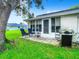 Private patio with rocking chairs, grill, and adjacent sunroom at 11836 Carissa Ln # B, New Port Richey, FL 34654