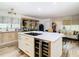 Open concept kitchen with large island and wine cooler, flows into living area at 11836 Carissa Ln # B, New Port Richey, FL 34654