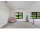 Living room with pink armchair, ceiling fan and sliding doors to sunroom at 9108 Bassett Ln # B, New Port Richey, FL 34655