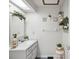 Charming bathroom with a single vanity, decorative shelving, and plants at 1096 Florian Way, Spring Hill, FL 34609