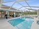 Inviting pool area with screened enclosure and lounge chairs at 1096 Florian Way, Spring Hill, FL 34609