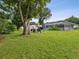 Spacious backyard with patio furniture under a large tree at 1096 Florian Way, Spring Hill, FL 34609