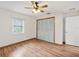 Bright bedroom with wood-look floors, window, and built-in closet at 1096 Florian Way, Spring Hill, FL 34609