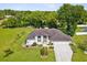 House with a three-car garage and a large, lush lawn at 1096 Florian Way, Spring Hill, FL 34609