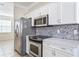 Modern kitchen with white cabinets, stainless steel appliances, and quartz countertops at 5614 Red Snapper Ct, New Port Richey, FL 34652