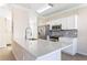 Modern kitchen with white cabinets, quartz countertops, and stainless steel appliances at 5614 Red Snapper Ct, New Port Richey, FL 34652