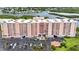 Aerial view of a large, light peach colored condominium building with parking and waterfront views at 4516 Seagull Dr # 414, New Port Richey, FL 34652