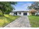 Charming ranch-style home with a black garage door and well-manicured lawn at 12119 Landfair St, Spring Hill, FL 34608