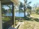 Backyard view showcasing a serene lake framed by mature trees and lush landscaping, creating a peaceful retreat at 12307 Fieldstone Ln, Hudson, FL 34667