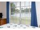 Bedroom view shows a waterfront view framed by windows and blue curtains at 12307 Fieldstone Ln, Hudson, FL 34667