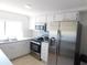Well-equipped kitchen with stainless steel appliances and white cabinets, providing a clean and modern space at 12307 Fieldstone Ln, Hudson, FL 34667
