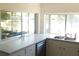Bright kitchen features white countertops, stainless steel sink, and serene lake views at 12307 Fieldstone Ln, Hudson, FL 34667