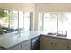 Bright kitchen features white countertops, stainless steel sink, and serene lake views at 12307 Fieldstone Ln, Hudson, FL 34667