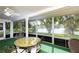Inviting screened lanai featuring a ceiling fan, outdoor dining set, and a beautiful view of the serene lake at 12307 Fieldstone Ln, Hudson, FL 34667