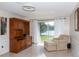 Bright living room with sliding glass doors leading to the lake, tiled floors and a comfortable armchair at 12307 Fieldstone Ln, Hudson, FL 34667