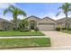 Single-story home with beige exterior, two-car garage, and landscaped yard at 11724 Heritage Point Dr, Hudson, FL 34667