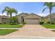 Single story home with beige exterior, two car garage, and landscaped yard at 11724 Heritage Point Dr, Hudson, FL 34667
