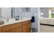 Double sink bathroom with wood cabinets and bedroom view at 11724 Heritage Point Dr, Hudson, FL 34667