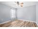 Light grey bedroom with wood-look tile flooring and window at 34838 Arbor Green Pl, Zephyrhills, FL 33541