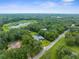 Aerial view showcasing a house near a pond, surrounded by trees and open space at 18713 Bonnie Dr, Spring Hill, FL 34610