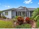 Landscaped backyard with screened patio and lush plants at 18937 Grand Club Dr, Hudson, FL 34667