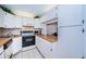 Bright kitchen features wood laminate countertops, white cabinets, and modern appliances at 2522 Pine Ridge S Way # A2, Palm Harbor, FL 34684