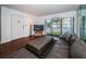 Bright living room with wood floors, sofa, and view to balcony at 2522 Pine Ridge S Way # A2, Palm Harbor, FL 34684