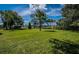 Expansive green lawn with mature trees and lush landscaping at 2522 Pine Ridge S Way # A2, Palm Harbor, FL 34684