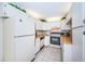 Galley-style kitchen with white cabinets and appliances at 2522 Pine Ridge S Way # A2, Palm Harbor, FL 34684