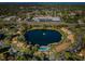 Aerial view of community with lake, pool, and buildings at 2522 Pine Ridge S Way # A2, Palm Harbor, FL 34684