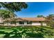 Back exterior view of condo with lush green lawn at 2522 Pine Ridge S Way # A2, Palm Harbor, FL 34684