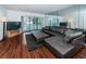 Spacious living room featuring a large sectional sofa and wood-look flooring at 2522 Pine Ridge S Way # A2, Palm Harbor, FL 34684