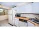 Bright kitchen features wood laminate countertops, white cabinets, and modern appliances at 2522 Pine Ridge S Way # A2, Palm Harbor, FL 34684